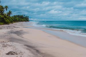 una playa de arena con el océano al fondo en Ceylon Good Vibes Villa, en Dikwella