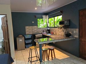 a kitchen with a counter and some stools in it at Villa Granja Agua Azul-wi-fi-AC-6 Personas-parqueo in Agua Azul
