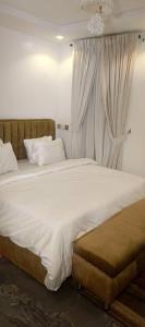 a bedroom with a large white bed with a window at Micangelo shortlet apartment in Idimu