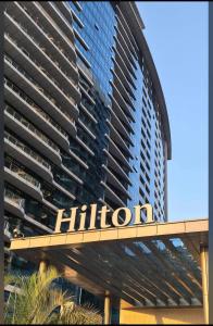 een gebouw met het hilton bord ervoor bij Luxury 1BR with Nile View at Hilton Hotel in Caïro