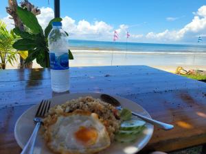 un piatto di cibo con un uovo e una bottiglia d'acqua di The wide pool villa trat a Ban Nong Wiwat
