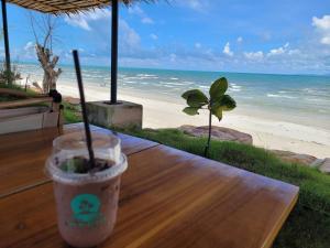 una tazza di caffè appoggiata su un tavolo vicino alla spiaggia di The wide pool villa trat a Ban Nong Wiwat