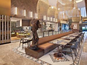 un restaurante con mesas y una estatua en el medio en Mercure Pangkalan Bun, en Pangkalan Bun
