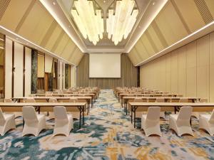 una sala de conferencias con mesas, sillas y una pantalla en Mercure Pangkalan Bun, en Pangkalan Bun 55 fotos más