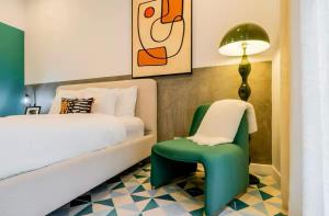 a bedroom with a bed and a green chair at Stunning 1BR in Santa Ana Best Area in Panama City