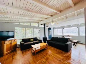 a living room with two couches and a tv at Sunny Point Resort in Parry Sound