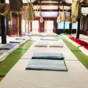 una habitación con una fila de colchones en el suelo en Eco Homestay Mai Chau - Venuestay, en Mai Chau
