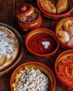 a group of bowls of food on a wooden table at Pik Talgar Eco Village in Talghar