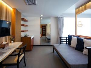 Peach Blossom Resort & Pool Villa - SHA Plus في شاطئ كاتا: غرفة معيشة مع أريكة وغرفة طعام