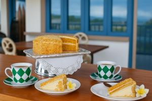 a table with slices of cake and cups of coffee at The Tree House Port Vila in Port Vila