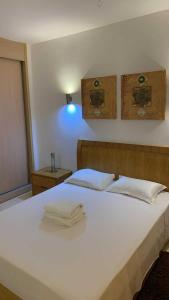 a bedroom with a white bed with towels on it at Vila verde Resort in Santa Maria
