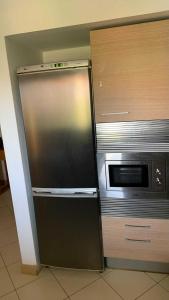 a stainless steel refrigerator next to a microwave at Vila verde Resort in Santa Maria