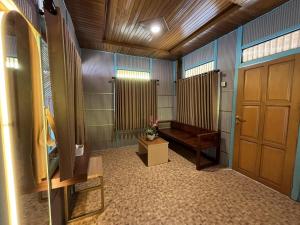 bagno con panca e porta in legno di Onsen Resort Kaliurang a Mantaak