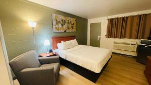 Swan RiverNelson Hotel的一间酒店房间，里面有一张床和一把椅子