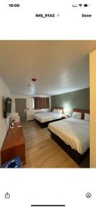 una habitación de hotel con dos camas y un escritorio en Nelson Hotel, en Swan River