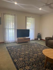 un soggiorno con TV a schermo piatto e divano di Cheerful 2 bedroom townhouse with secure parking a Mildura