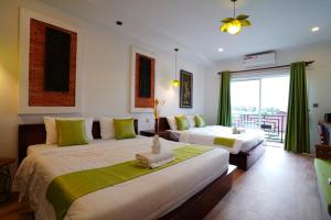 a hotel room with two beds and a balcony at Angkor Rithy Residences in Siem Reap +30 photos