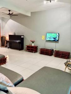 a living room with a piano and a flat screen tv at Ipoh Meru Animation Homestay by Grab A Stay in Ipoh