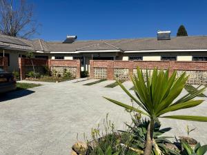 ein Haus mit einem Innenhof mit einer Palme in der Unterkunft Hatfield staylax Manor 2 in Harare