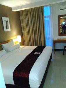 ein Schlafzimmer mit einem großen Bett in einem Hotelzimmer in der Unterkunft Oyo Apartment Deluxe by Egi in Jakarta