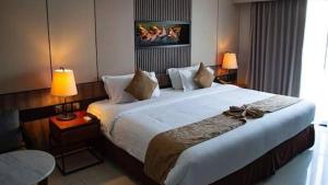 ein großes Bett in einem Hotelzimmer mit zwei Lampen in der Unterkunft Oyo Apartment Deluxe by Egi in Jakarta