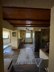 eine Küche und ein Wohnzimmer mit Kühlschrank und Tisch in der Unterkunft Panonska jezera ZELENA OAZA in Tuzla