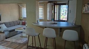 eine Küche und ein Wohnzimmer mit Tisch und Stühlen in der Unterkunft Panonska jezera ZELENA OAZA in Tuzla