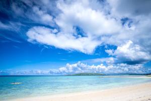 una spiaggia con una barca in acqua di 家族の笑顔 希望ヶ丘ビーチまで徒歩5分でのんびり家族ステイ Coral Onnason a Onna