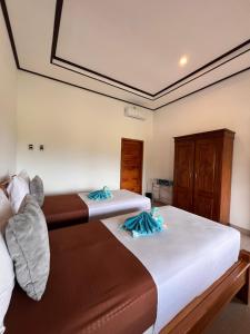 una camera da letto con due letti con asciugamani sopra di Villa Saudara a Data