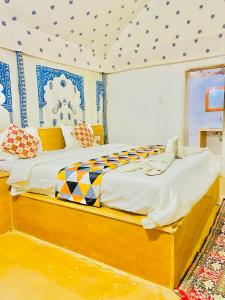 ジャイサルメールにあるDunes Villa Desert Campの青と白の天井の部屋にベッドが2つある