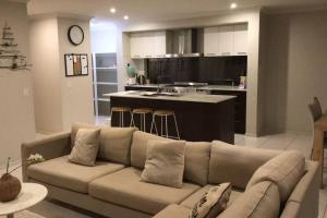 Geelong 3 Bedroom Lovely House في Hamlyn Heights: غرفة معيشة مع أريكة ومطبخ