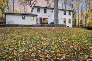 una casa bianca con un mucchio di foglie davanti di The Hideaway 4200 Luxury 4BR Home with Theater Game Room Fire Pit and Gym a Evansville