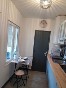 a small kitchen with a table and a black door at City 18 in Bourges