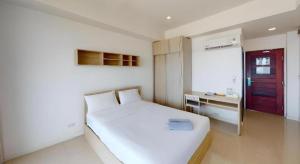 een slaapkamer met een wit bed en een rode deur bij Seabreeze Bangsaen in Ban Thai Don (1)