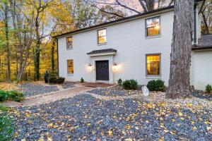 una casa bianca con un albero di fronte di The Hideaway 4200 Luxury 4BR Home with Theater Game Room Fire Pit and Gym a Evansville