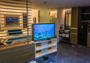 a living room with a flat screen tv on a stand at The Lu'um House in Tuxtla Gutiérrez