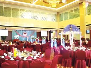 una grande sala banchetti con tavoli e sedie rossi di Xiangtan Xintian International Hotel a Yisuhe