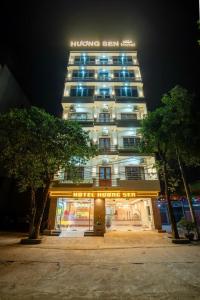 宁平Hương Sen Hotel的晚上，建筑物顶部有标志