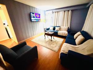 Una sala de estar con un sofá y un televisor en Charming Cape Cod Home in Glen Burnie, MD, en Glen Burnie