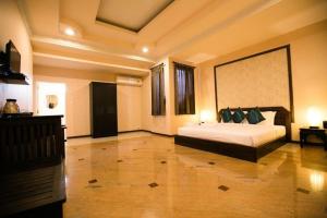 um quarto com uma cama grande em um quarto em Pharadhevi em Ban Dung