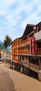 un edificio con un cartel al costado de una calle en Hotel BHRIGU, en Manali