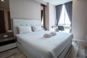 a bedroom with a large white bed with towels on it at RedDoorz Homestay VIP in Jakarta
