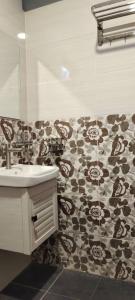 a bathroom with a sink and a patterned wall at Pagohhomestay Humaira282 in Pagoh