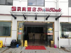 an entrance to a building with a sign on it at Shell Linzhi Bayi Area G318 Shuangyong Road Hotel in Dagzê