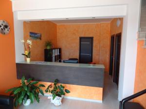 ein Büro mit orangefarbenen Wänden und einer Rezeption in der Unterkunft Affittacamere Rooms Di Matteo in San Paolo di Iesi