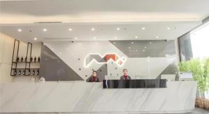 防城Borrman Hotel Fangchenggang High-speed Railway North Station Crystal International的两个人站在大厅的柜台上