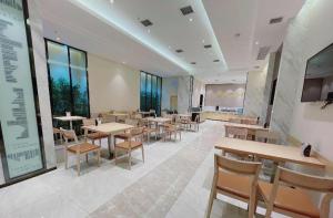 a dining room with tables and chairs and windows at City Comfort Inn Wuhan University Guangbutun Metro Station in Wuhan