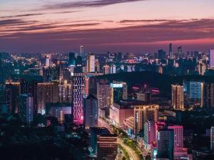 a city skyline at night with illuminated buildings at City Comfort Inn Wuhan University Guangbutun Metro Station in Wuhan
