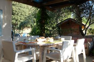 a wooden table and chairs on a patio at casa di Rosa in Patrimonio