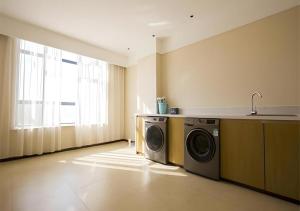 a laundry room with a washing machine and a sink at City Comfort Inn Xianning Tongshan Education Bureau in Tongshan